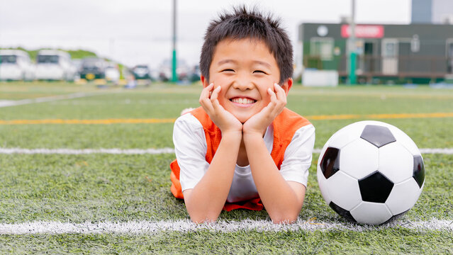 サッカーボールと一緒に笑顔を見せる少年選手