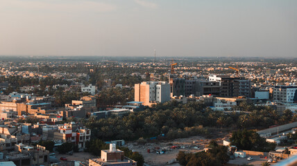 Obraz premium View of modern Karbala cityscape with construction and greenery in Iraq at sunset