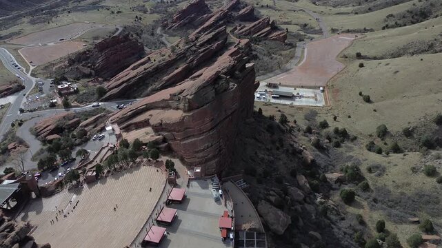 Amphitheatre sandstone sweep shows Red Rocks along Alameda Parkway with hogback slopes tilted sandstone walls. Warm rock textures, muted vegetation soft daylight shape terrain in Morrison, CO