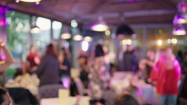 Guests sharing joyful moments at bustling patio with ambient lighting and cheerful chatter