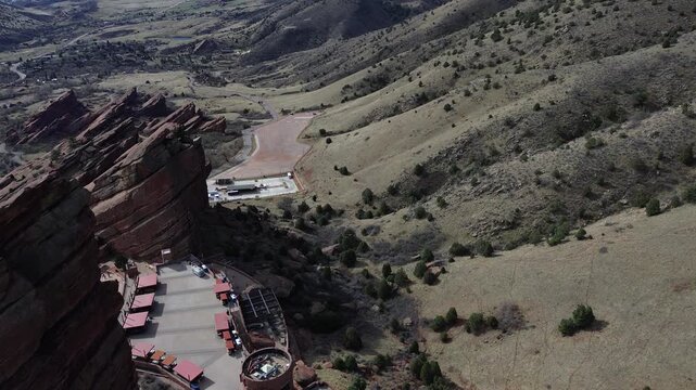 Hogback concert overlook shows Red Rocks near Alameda Parkway with steep hogback formations rising above venue. Layered sandstone, sparse foliage warm afternoon lighting in Morrison, CO