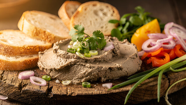 Vietnamese chicken liver p&acirc;t&eacute;, smooth and creamy texture, garnished with herbs, served on a rustic wooden board with toasted baguette slices, shallots, and pickled vegetables 