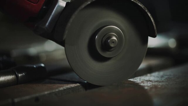 Cutting spinning angle grinder disc contacting metal on bench, spraying sparks while removing rivet