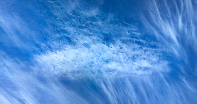Beautiful cloudscape of nature several white clouds on blue sky background in daytime. Fabulous swirling water vapors. Multi-tiered clouds of steam.