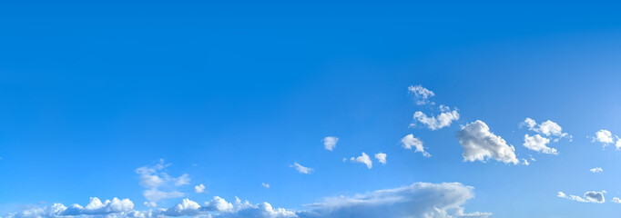 A gentle flight of cascading clouds on the horizon. Bright blue sky with cirrus clouds in high distance, horizontal smoke altitude banner. Weather, spring and summer, peace, hope and purity concept © codexserafinius