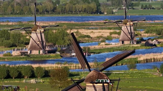Dutch traditional windmills turning in kinderdijk polder landscape