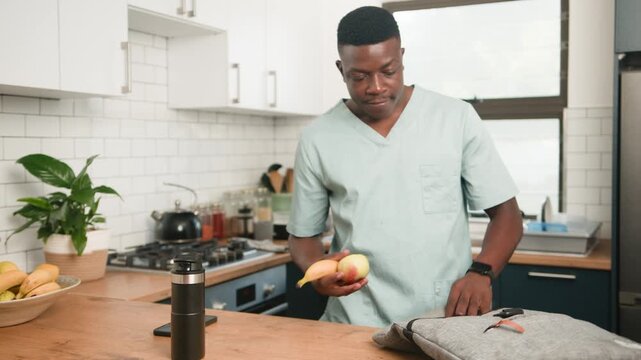 Young Professional in Scrubs Packs Healthy Lunch and Essentials for Work