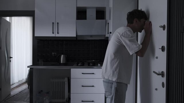 Agoraphobia and social anxiety concept with anxious man checking door peephole, fear of leaving apartment and psychological panic atmosphere