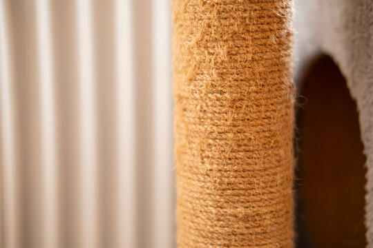 Frayed sisal rope on a worn cat scratching post providing a textured surface for pets to play