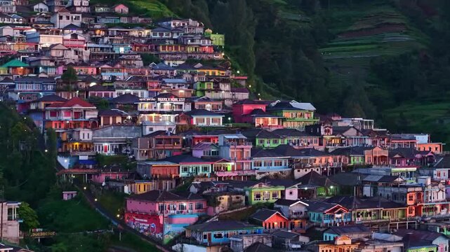 Detailed drone view of Nepal van Java village at blue hour, stacked colorful houses on Mount Sumbing slope.