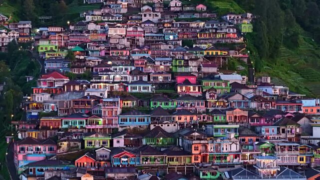 Early morning close-up of Nepal van Java homes, vibrant rooftops glowing before sunrise on mountain hillside.