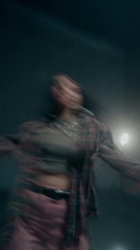 Vertical shot of young female hip hop dancer performing facing camera with blurred motion trails, social media story format