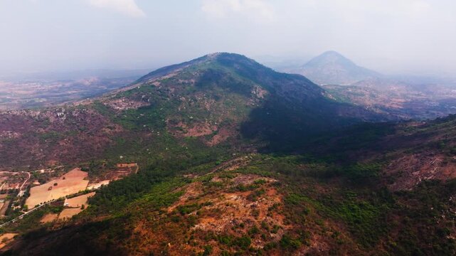 Mountains with fog, haze, sky, greenery and village at nandi hills, Bengaluru, karnataka, india. day time, push back shot, drone shot, 4k.