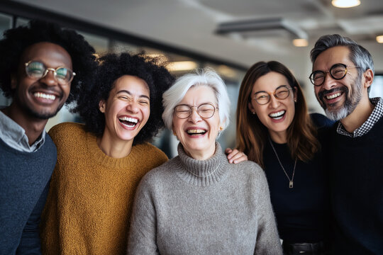 Diverse group of coworkers laughing together in a bright modern office, different ages ethnicities and abilities represented, inclusive workplace concept, natural candid moment