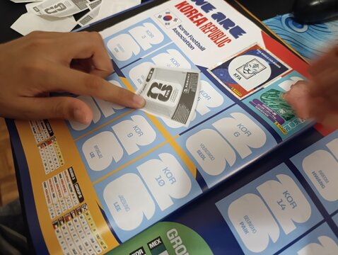 Crian&ccedil;a colando figurinhas no &aacute;lbum da Copa do Mundo - FIFA 2026 - World Cup 2026 - PANINI.