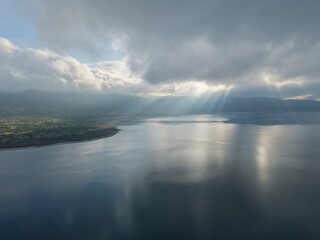 Fototapeta premium aerial view coastli. sunbeams from behind the clouds over the lakes. view from a drone of a lake in the mountains. High quality 4k footage