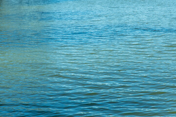 Obraz premium Clear water ripples in a lake under a sunny sky during mid afternoon in a natural setting