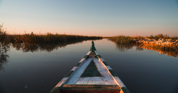 Exploring the tranquil waters of the Mesopotamian Marshes in Iraq during sunset