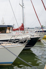 Obraz premium Luxury sailboats moored in modern marina harbor with calm water and nautical equipment