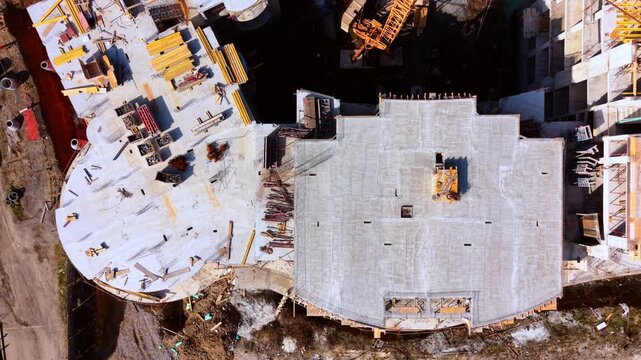 Csoncrete structures, formwork materials, and ground site elements. Top down drone perspective of apartment building foundation