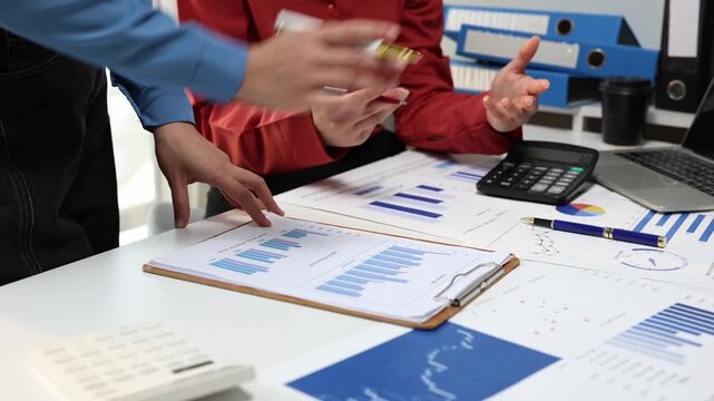 Business team analyzing financial data and marketing growth on a graph chart during a collaborative meeting in the office, discussing strategy and sales performance