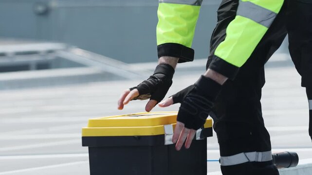 Male electrician installing solar panels carries toolbox containing tools ready safely inspect the solar panel equipment on the roof while performing field inspection.