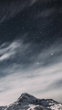 Stepantsminda, Georgia. Winter Night Starry Sky With Glowing Stars And Peak Of Mount