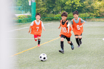 ドリブルの後シュートでゴールを狙うサッカー少年たち © Zoey106