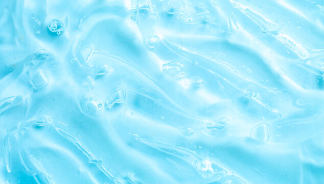 Cosmetic gel, serum, clear sample with a blue tint, close-up. Liquid cream with a foaming texture. Gel texture of a cosmetic product. Liquid cosmetic lotion for skin care.