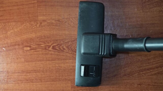 A cleaning tool attachment is positioned on a wooden surface, captured from four different angles.