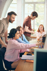 Fototapeta premium Office team collaborating near computer during customer support shift. Concept of call center workflow, helpdesk coaching, client communication, digital teamwork, and business service.