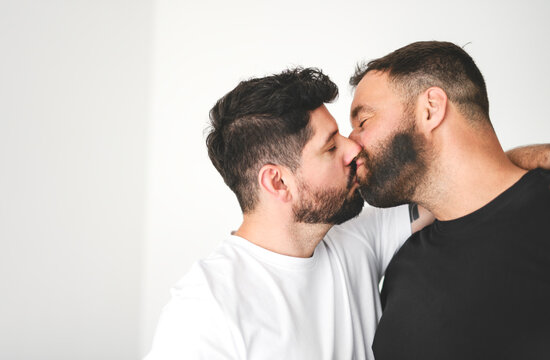 Young homosexuals gay couple love each other on a white background.