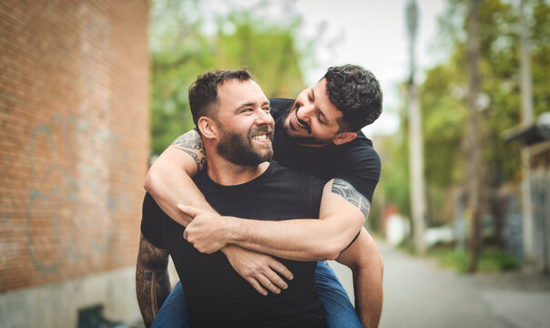 A Portrait of a happy gay couple outdoors in urban background