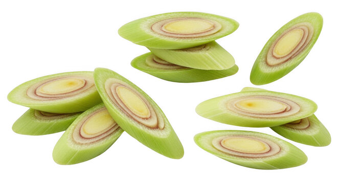 Freshly sliced lemongrass stalks arranged in small piles and scattered pieces showing concentric circular rings on a black background