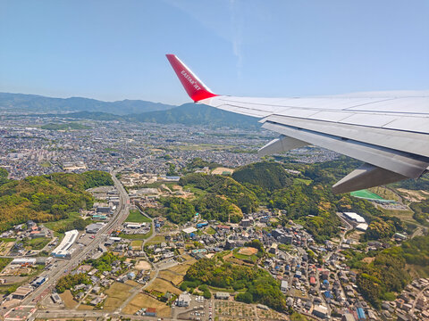 Fukuoka, Japan - April 25, 2026: The wing of an Eastar Jet Boeing 737 passenger airplane during takeoff and climb from Fukuoka Airport, viewed from a window seat.
