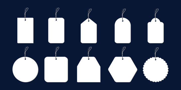 Collection of blank white tags and labels with strings on dark blue background