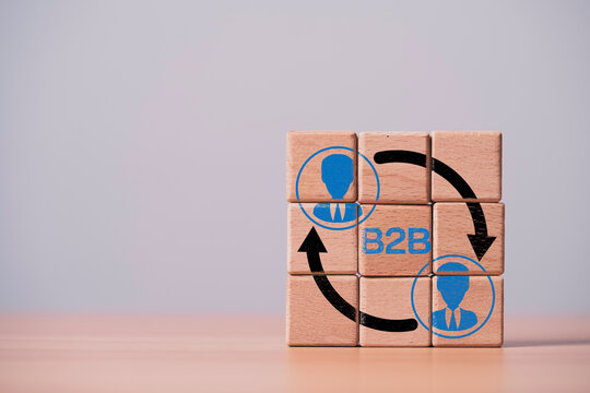 B2B business communication concept with wooden blocks and connected arrows, symbolizing corporate partnership, customer relationship, networking, collaboration, sales process and digital marketing.