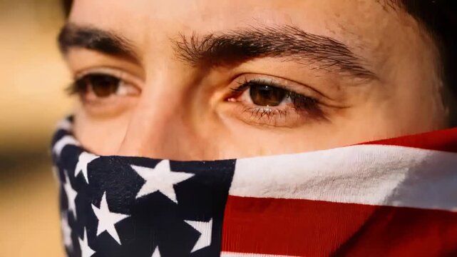 Starting gaze, man tracking right, blinking and relaxing in golden light, wearing US flag bandana
