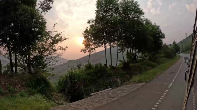 Cinematic rainforest road through Bwindi with clouds touching green hills in Uganda