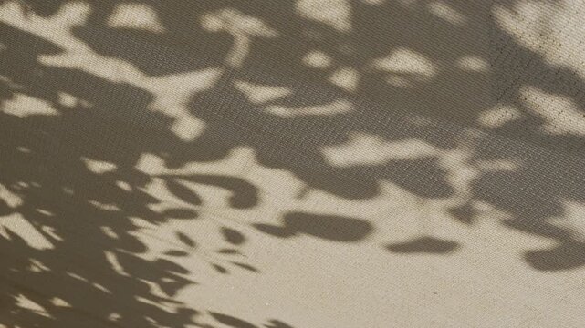 Refreshing summer wind lifting sunshade net roof with rustling tree shadows