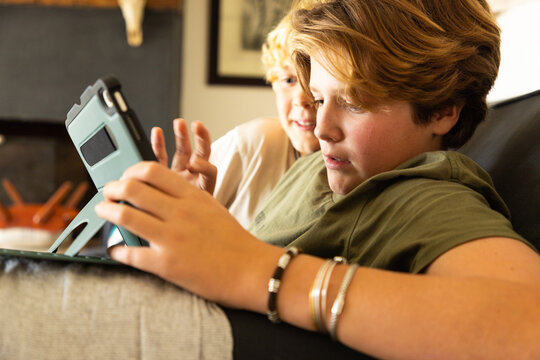 12 year old boy using tablet computer for gaming