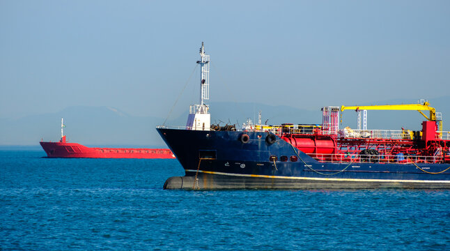 Bow and midship section of a dark blue chemical tanker floating peacefully