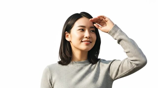 Woman shielding eyes from sun with a cheerful expression
