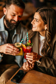 Happy couple toasting cocktails enjoying date night