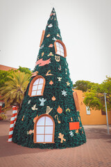 Obraz premium Large artificial Christmas tree designed like a fairy tale house with windows and ornaments, located outdoors in Willemstad, Curacao, Caribbean