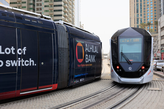 Dubai, UAE - August 16, 2025: A modern Alstom Citadis tram wrapped in a Samsung advertisement operating on the Dubai Tram network surrounded by skyscrapers.