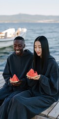 Obraz premium Two friends eating watermelon on a wooden dock by the sea for summer lifestyle poster and picnic background