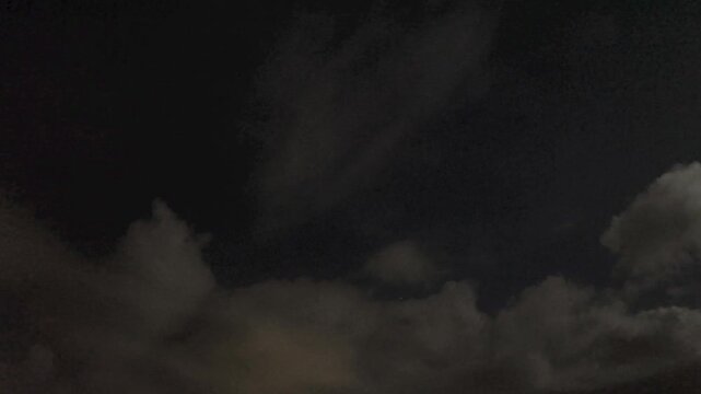 Pretty clouds moving in the dark sky