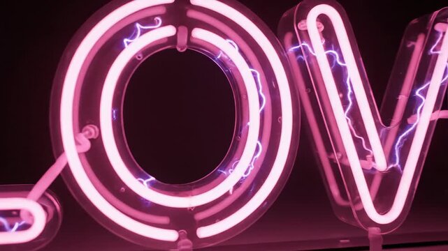 Glowing pink neon love sign on a dark background for Valentine's day or wedding celebration.