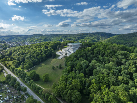 Aerial view of Walhalla memorial temple on a lush green hill overlooking the Danube valley under a cloudy blue sky Donaustauf, Bayern, Germany.